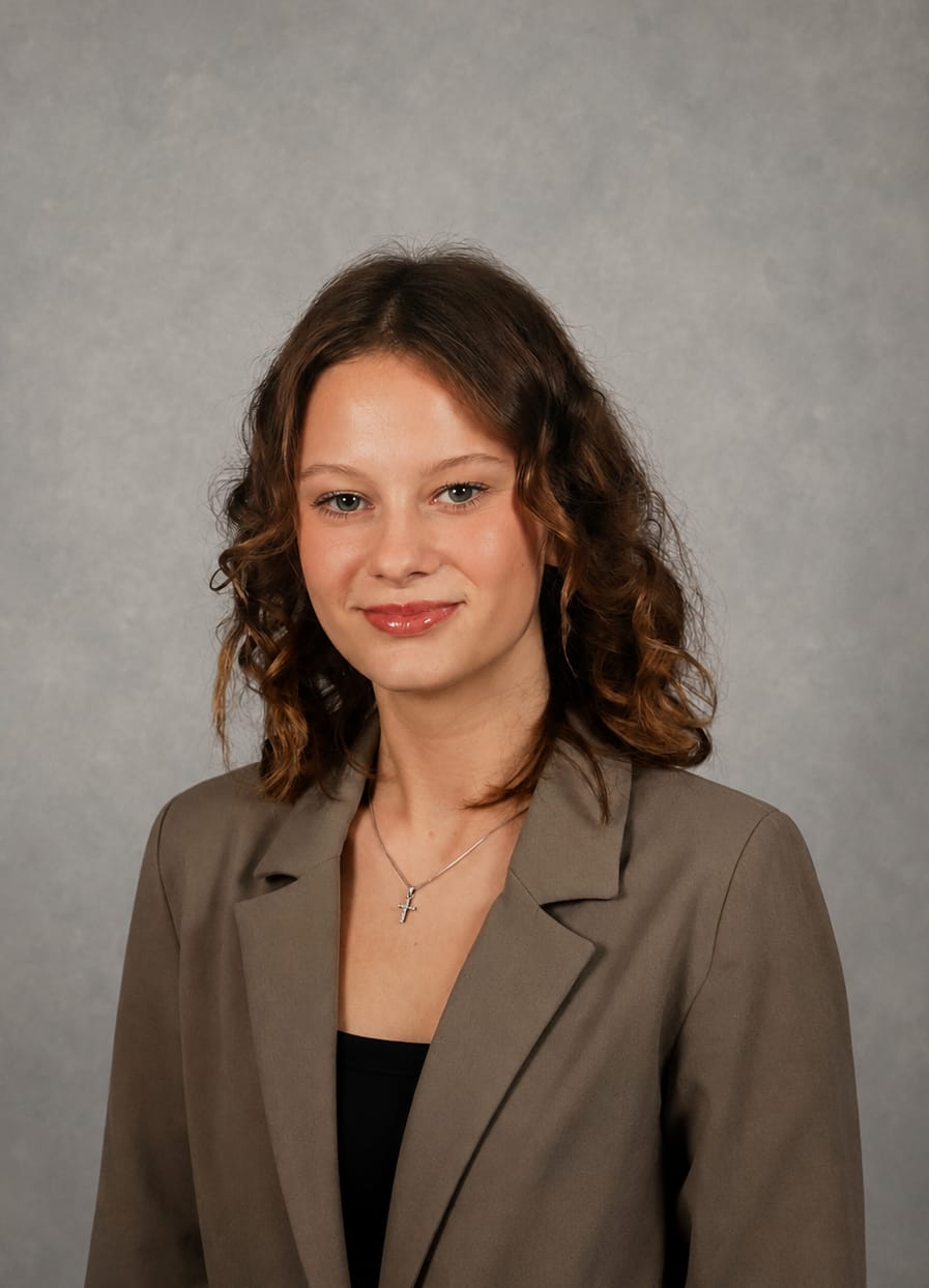 Portrait of Elena Ratkovic in a taupe blazer against a grey backdrop.